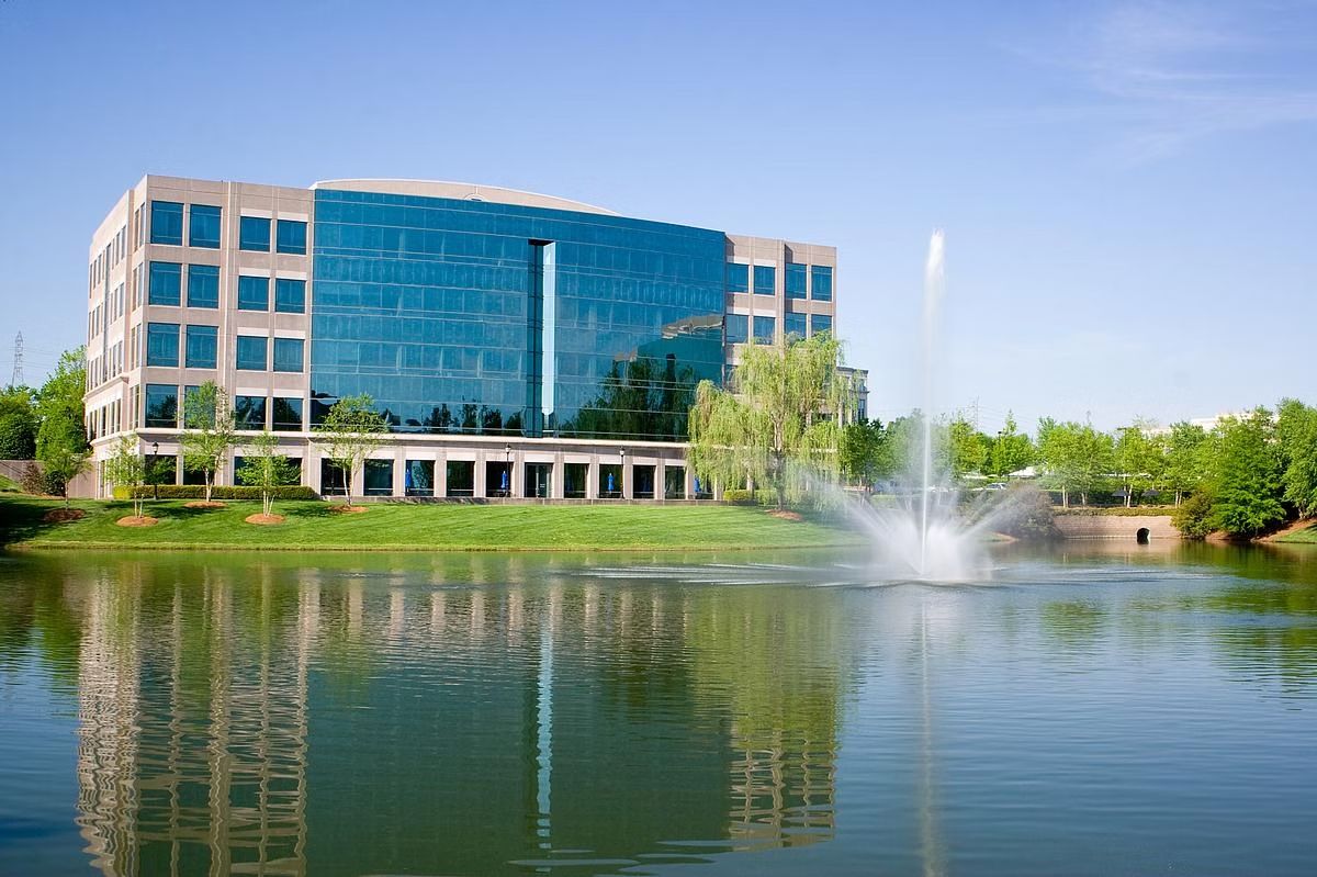 Charlotte corporate headquarters beside a landscaped lake and fountain